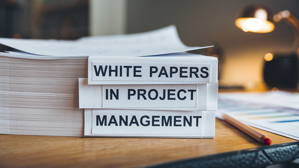 A photo of a stack of white papers with the title "White Papers in Project Management".