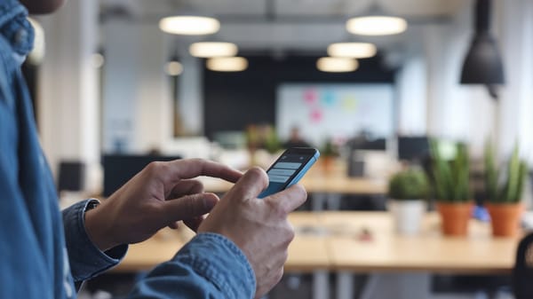 A cinematic shot of a man using his smartphone to search for a phone number.