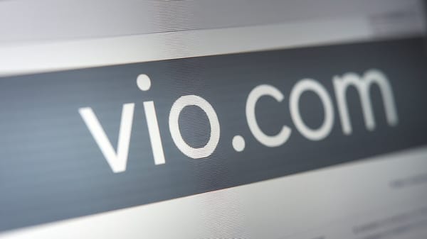 A photo of a website domain name "vio.com" displayed on a computer screen. 